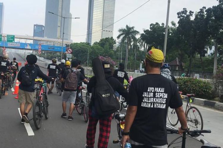 Sejumlah pegiat sepeda mengawal pencopotan rambu hak ekslusif bagi pesepeda road bike oleh petugas Dinas Perhubungan DKI Jakarta, Minggu (13/6/2021). Rambu yang dipasang di Jalan Layang Non Tol (JLNT) Kampung Melayu-Tanah Abang itu menuai protes lantaran dianggap diskriminatif bagi pesepeda non-road bike. 