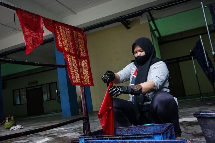 Eni (39), warga Rusun Pulogebang, menunjukkan kain batik tulis yang ia lukis, Jumat (18/6/2021). Eni merupakan salah satu korban gusuran yang kini berjuang memungut kembali sisa-sisa masa kejayaannya sebelum digusur dengan cara aktif terlibat sebagai pengrajin batik.