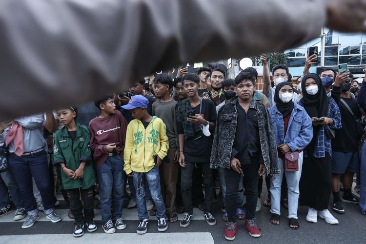 Pengunjung menunggu menyaksikan peragaan busana jalanan di kawasan Dukuh Atas, Jakarta, Rabu (20/7/2022).  Fenomena Citayam Fashion Week di kawasan Dukuh Atas mendadak viral karena gaya busana nyentik yang didominasi anak muda dari Depok, Citayam, dan Bojonggede.