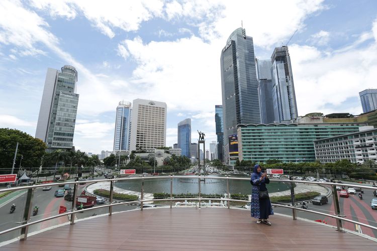 Pengunjung berfoto di anjungan Halte Transjakarta Bundaran Hotel Indonesia, Jakarta, Jumat (28/10/2022). Warga Ibu Kota datang ke halte yang belum sepenuhnya rampung itu untuk antre berfoto demi dapat latar belakang Patung Selamat Datang.