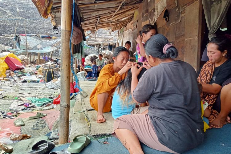 Aktivitas para ibu-ibu dan anak-anak yang tinggal di Kelurahan Ciketing Udik, Kota Bekasi pada Minggu (11/12/2022). Mereka tinggal di rumah semi permanen tepat di samping TPST Bantargebang. Tidak ada yang menggunakan masker saat beraktivitas karena mereka tidak merasa terganggu dengan polusi udara berupa debu dan bau dari tumpukan sampah di landfill TPST Bantargebang itu.