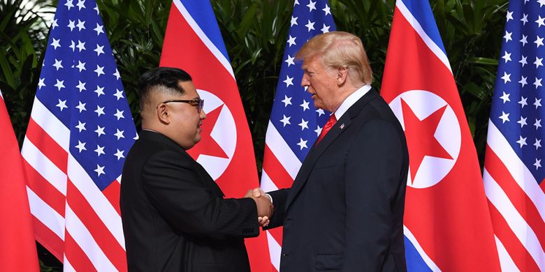 Pemimpin Korea Utara Kim Jong Un (kiri) bersalaman dengan Presiden AS Donald Trump pada pertemuan bersejarah antara AS-Korea Utara, di Hotel Capella di Pulau Sentosa, Singapura, Selasa (12/6/2018). Pertemuan ini merupakan yang pertama kalinya bagi pemimpin kedua negara dan menjadi momentum negosiasi untuk mengakhiri kebuntuan permasalahan nuklir yang telah terjadi puluhan tahun.