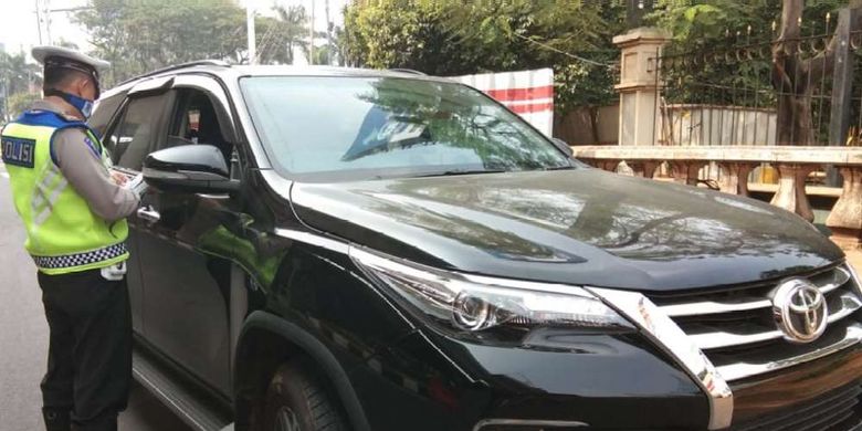 Polisi memberhentikan sebuah mobil bermerek Toyota Fortuner berwarna hitam dengan pelat nomor B 100 NAR di ruas Jalan MT Haryono ke arah Jalan Gatot Subroto, Jakarta, Rabu (1/8/2018). Petugas kepolisian mulai memberlakukan penindakan berupa tilang terhadap pengendara mobil yang melanggar di kawasan perluasan sistem ganjil-genap.