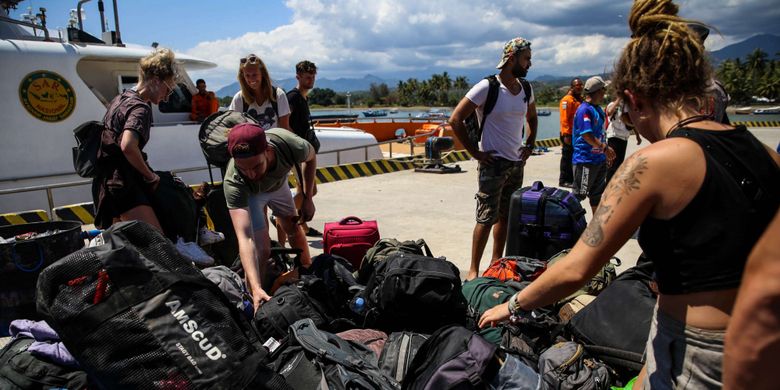 Wisatawan mancanegara membawa barang bawaanya saat turun dari kapal cepat di Pelabuhan Bangsal, Lombok Utara, Nusa Tenggara Barat, Selasa (7/8/2018). Wisatawan, pekerja, dan warga dievakuasi dari Gili Trawangan, Gili Air, dan Gili Meno menuju Pelabuhan Bangsal untuk diberangkat ke Kota Mataram pascagempa Lombok hari kedua.