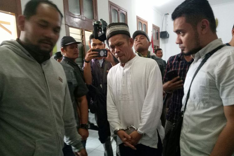 Asep Maftuh (45) yang tampak mengenakan pakaian muslim tengah mendapatkan pengawalan usai menjalani sidang perdananya di Pengadilan Negeri (PN) Bandung, Jalan LLRE Martadinata, Kota Bandung, Kamis(24/5/2018). Asep didakwa Pembunuhan Berencana.