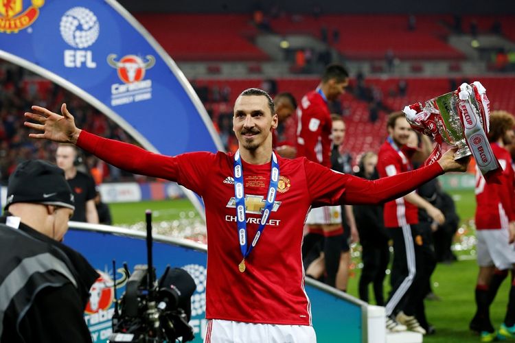 Penyerang Manchester United, Zlatan Ibrahimovic, memegang trofi Piala Liga Inggris setelah tim berjulukan Setan Merah tersebut menang 2-1 atas Southampton pada final di Stadion Wembley, Minggu (26/2/2017).  