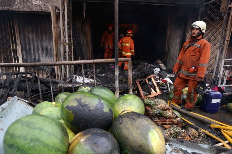 Aktivitas para petugas pemadam kebakaran saat memadamkan sebuah toko yang terbakar di Pasar Kebayoran Lama, Jakarta Selatan, Selasa (13/6/2017). Sebanyak 15 unit mobil damkar dikerahkan ke lokasi.