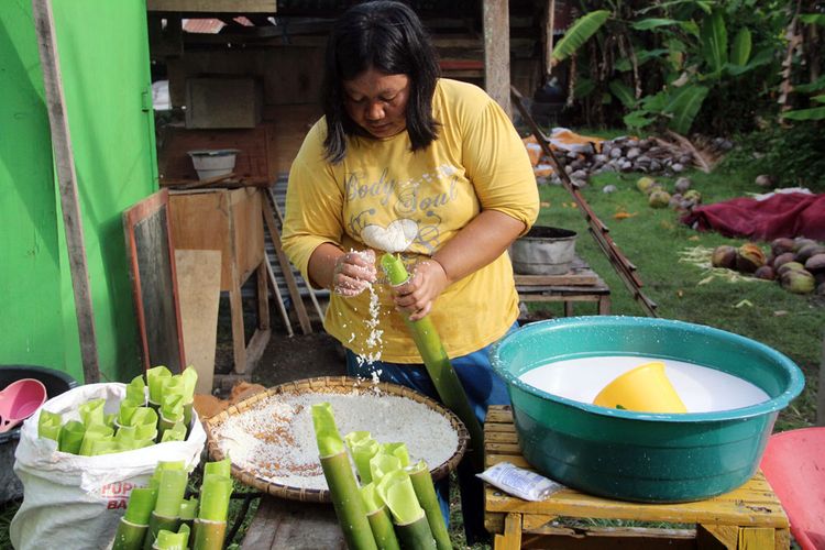 Seorang wanita Jawa Tondano di Yosonegoro mengisi bambu yang dilapisi dengan daun pisang muda dengan beras yang telah dicampur dengan santan, bawang putih dan jahe.