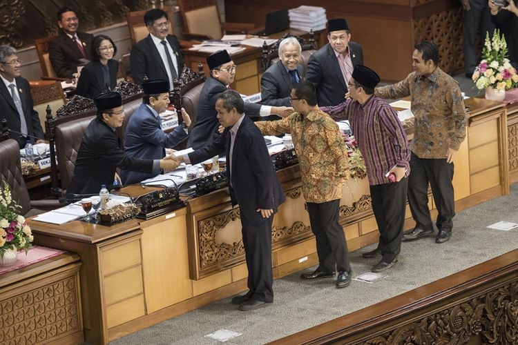Anggota Fraksi PKS Al Muzammil Yusuf (kedua kanan), Sekretaris Fraksi PAN Yandri Susanto (ketiga kanan), Wakil Ketua F-Demokrat Benny K Harman (keempat kanan) dan Ketua Fraksi Gerindra Ahmad Muzani (kanan) berjabat tangan dengan lima pimpinan DPR untuk meninggalkan ruang sidang (walk out) sebelum pengambilan keputusan pengesahan RUU Pemilu pada sidang Paripurna DPR ke-32 masa persidangan V tahun sidang 2016-2017 di Kompleks Parlemen Senayan, Jakarta, Jumat (21/7/2017) dini hari. DPR mengesahkan RUU Pemilu menjadi undang-undang setelah melalui mekanisme dan memilih opsi A, yaitu Presidential Threshold sebesar 20 persen kursi DPR atau 25 persen suara nasional.