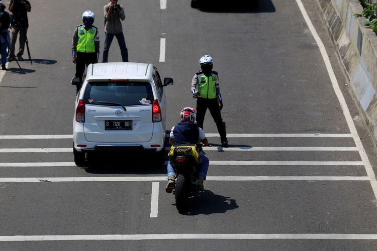 Polisi melakukan razia sepeda motor yang nekat menerobos ke jalan layang non tol (JLNT) Kampung Melayu-Tanah Abang, Jakarta Selatan, Rabu (26/7/2017). Pengendara motor masih nekat memasuki dan melintasi JLNT tersebut baik dari arah Tanah Abang maupun Kampung Melayu.