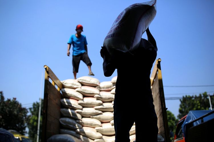 Buruh memasukkan beras ke mobil di Pasar Induk Beras Cipinang, Jakarta Timur, Rabu (26/7/2017). Penetapan Harga Eceran Tertinggi (HET) untuk komoditas beras memberikan pengaruh yang besar kepada para petani dan pedagang sehingga menyebabkan pasokan beras ke pasar induk anjlok.