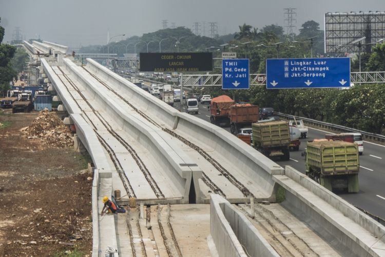 Kendaraan melintas di samping proyek pembangunan kereta ringan atau Light Rail Transit (LRT) rute Cibubur-Cawang di Tol Jagorawi, Cibubur, Jakarta, Kamis (10/8/2017). Pengerjaan proyek pembangunan LRT Jabodetabek yang meliputi tiga rute, yaitu  rute Cibubur-Cawang sepanjang 14,5 km telah mencapai 37 persen, rute Bekasi Timur-Cawang sepanjang 17,1 km telah mencapai 17 persen sementara rute Cawang-Dukuh Atas sepanjang 10,5 km baru mencapai tiga persen. ANTARA FOTO/Aprillio Akbar/aww/17.