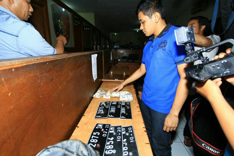 Seorang anggota kepolisian memperlihatkan sejumlah barang bukti dalam penggerebekan komplotan curanmor di Mapolresta Bogor Kota, Rabu (16/8/2017).