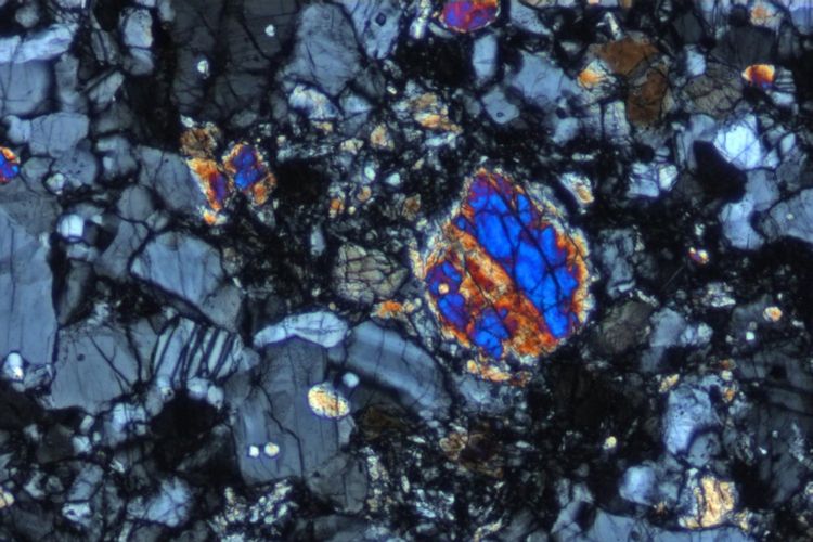 Gambar cahaya terpolarisasi silang (bidang pandang 0,07mm) sebagian bagian dalam Rusty Rock mencairkan breksi. Mineral abu-abu adalah butiran plagiokla, dan biji-bijian berwarna cerah adalah butiran pyroxene.