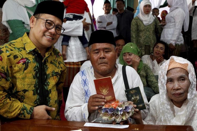 Ketua Umum PKB, Muhaimin Iskandar mendampingi pasangan pengantin Mang Kus dan Marsiati mengikuti nikah massal yang diselenggarakan Partai Kebangkitan Bangsa di KUA Menteng, Jakarta Pusat, Jumat (25/8/2017). Sebanyak 103 pasangan pengantin mengikuti acara ini.