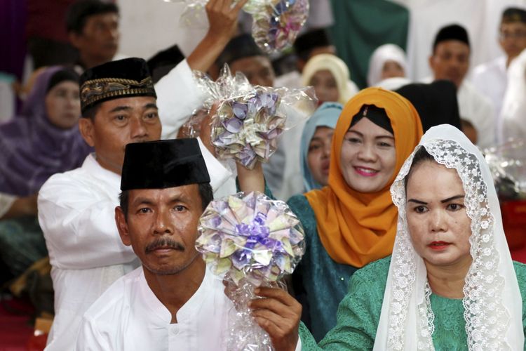 Pasangan pengantin mengikuti nikah massal yang diselenggarakan Partai Kebangkitan Bangsa di KUA Menteng, Jakarta Pusat, Jumat (25/8/2017). Lebih dari seratus pasang pengantin mengikuti acara ini.