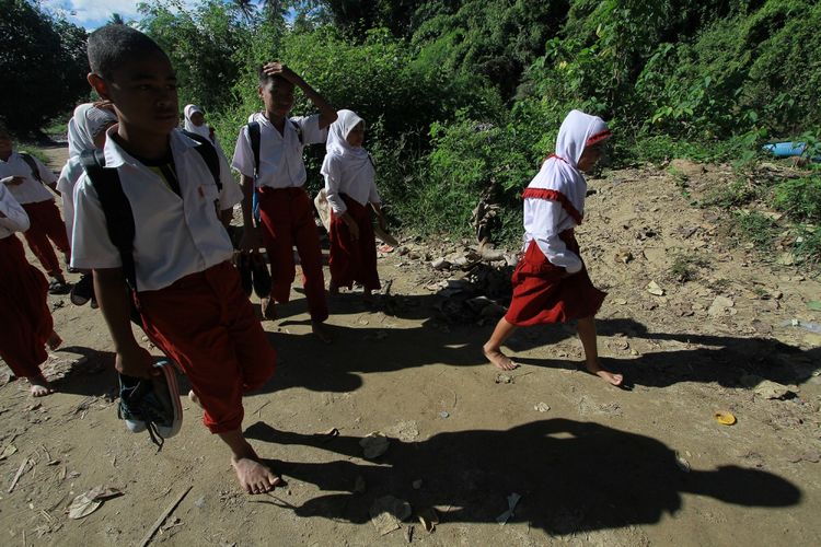 Sejumlah siswa berjalan kaki untuk berangkat ke Sekolah Dasar (SD) Negeri 1 Bulango Ulu, Kabupaten Bone Bolango, Gorontalo, Selasa (5/9/2017). Sebanyak 30 siswa dari Mongiilo Utara dan Ilomata harus berjalan kaki sejauh 2-4 kilometer dari rumah mereka dan menyeberangi sungai untuk berangkat ke sekolah yang berada di Mongiilo Induk.