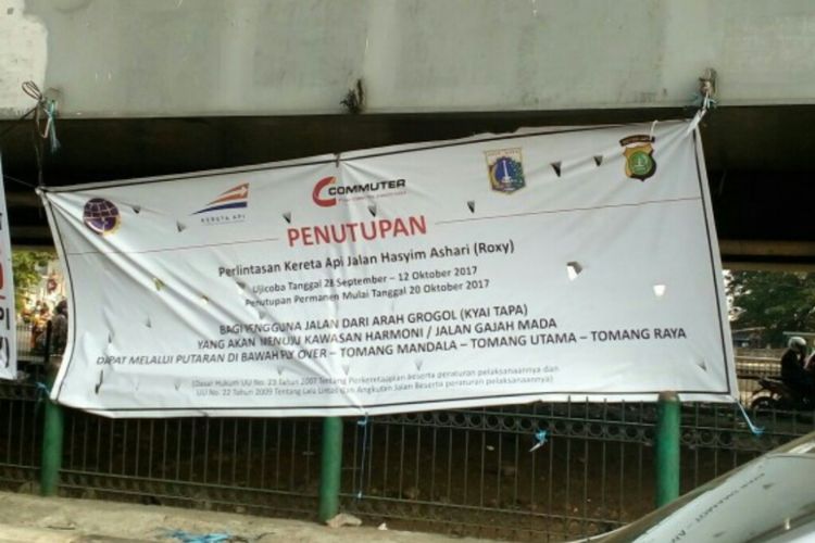 Banner berisi pemberitahuan penutupan perlintasan kereta api terpasang di tembok fly over yang terletak di depan ITC Roxy, Jalan KH Hasyim Ashari, Gambir, Jakarta Pusat, Selasa (12/9/2017).