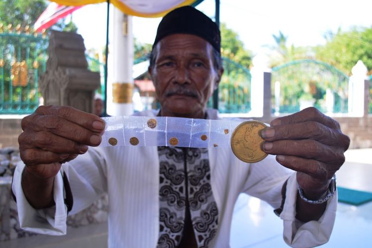 Warga memperlihatkan beragam ukuran koin emas (dirham) di Kompleks Makam Sultan Kerajaan Malikussaleh, Kecamatan Samudera, Aceh Utara