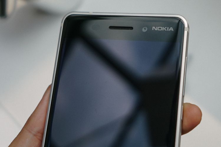 Logo Nokia bertengger di sisi depan, di sebelah unit kamera depan 8 megapiksel milik Nokia 6.