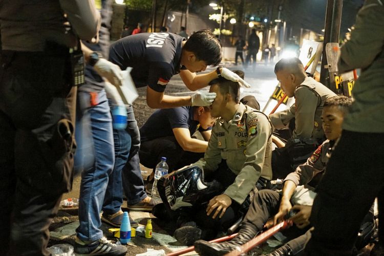 Seorang polisi yang terluka sedang diobati setelah terjadi bentrok dengan massa pengepung kantor YLBHI, Jakarta Pusat, Senin (18/9/2017) dini hari.