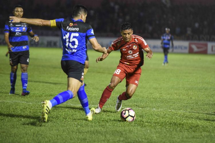 Pemain Semen Padang, Irsyad Maulana (kanan) dan pemain Madura United, Fabiano, berebut bola pada lanjutan Liga 1 Indonesia di Stadion H Agus Salim Padang, Jumat (6/10/2017). 