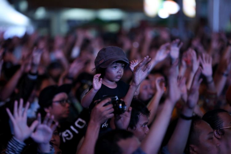 Bocah menyaksikan penampilan musisi di Syncronize Fest 2017 di Gambir Expo Kemayoran, Jakarta, Sabtu (7/10/2017). Festival musik yang berlangsung selama tiga hari hingga Minggu (8/10/2017) tersebut menampilkan beberapa musisi di antaranya ada Bangkutaman, Jason Ranti, Adhitya Sofyan, Float, Pee Wee Gaskin, Indische Party, dan Hello Dangdut. KOMPAS IMAGES/KRISTIANTO PURNOMO
