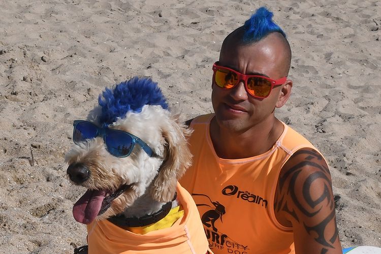 Anjing peserta Derby dan pemiliknya, Kentucky Gallahue, saat menunggu giliran untuk beraksi di kompetisi selancar Surf City Surf Dog Ke-9 di Huntington Beach, California, Sabtu (23/9/2017) waktu setempat. Lebih dari 70 ekor anjing menunjukkan keahlian dengan menaklukkan ombak setinggi satu sampai tiga kaki, dengan pembagian kategori untuk anjing kecil, sedang, besar, dan ekstra besar.