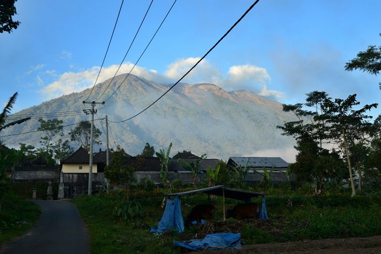 Pemandangan Gunung Agung di Karangasem, Bali, dilihat pada Kamis (21/9/2017). Sebagian besar masyarakat di sekitar gunung telah mengungsi secara mandiri karena tanda-tanda yang dirasakan saat ini mirip dengan kejadian sebelum Gunung Agung meletus pada 1963 silam.