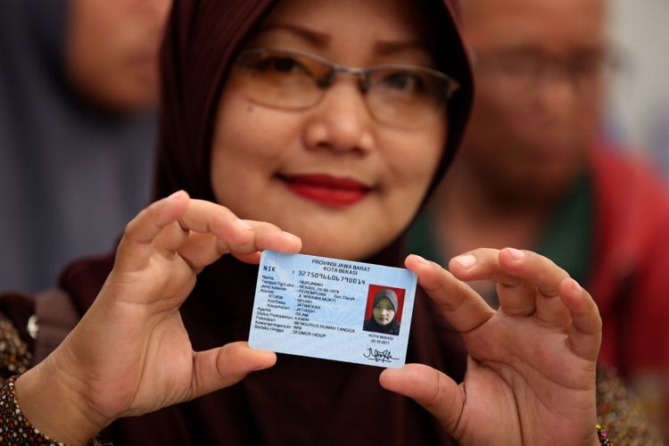 Warga menunjukkan e-KTP yang baru dicetak di stan pelayanan dan pencetakan e-KTP di Taman Mini Indonesia Indah (TMII), Jakarta, Jumat (20/10/2017).  Kegiatan yang digelar antara Dinas Kependudukan dan Catatan Sipil DKI bekerja sama dengan Direktorat Jenderal Kependudukan dan Catatan Sipil Kementerian Dalam Negeri ramai diserbu warga yang yang belum memiliki e-KTP. KOMPAS IMAGES/KRISTIANTO PURNOMO
