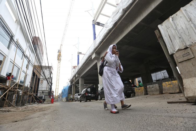 Sejumlah warga melintas di bawah proyek mass rapid transit (MRT), jalan Fatmawati, Jakarta Selatan, Senin (23/10/2017). 26 lahan di Jalan Fatmawati akan segera dibongkar untuk proyek pembangunan MRT, Proyek ini diperkirakan akan rampung pada tahun 2018.