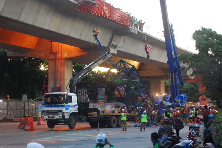 Sejumlah pekerja proyek Tol Bogor Outer Ring Road (BORR) dari PT Wijaya Karya sedang mengevakusi tower crane portable yang terjatuh saat pemasangan barrier pembatas jembatan, Kamis (26/10/2017).
