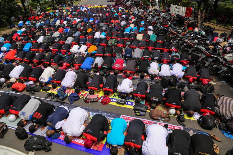 Massa buruh melakukan shalat jumat sebelum melakukan aksi unjuk rasa di depan Balai Kota DKI Jakarta, Jalan Medan Merdeka Selatan, Jumat (10/11/2017). Buruh menolak upah minimum provinsi (UMP) DKI Jakarta 2018 yang telah ditetapkan Gubernur DKI Jakarta Anies Baswedan. KOMPAS.com/GARRY ANDREW LOTULUNG