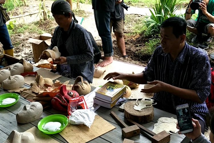 Maestro pembuatan wayang kulit, Saigo (kanan), menjelaskan cara pembuatan wayang kulit kepada peserta workshop dalam Kulon Progo Festival 2017 di Bendung Khayangan, DI Yogyakarta, Sabtu (25/11/2017).