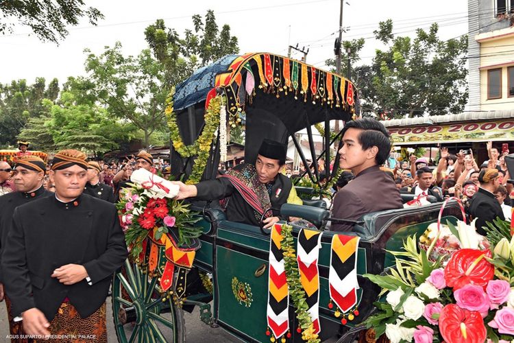 Presiden Joko Widodo bersama Ibu Negara Iriana dan putra mereka, Kaesang Pangarep, membagikan kaus pada warga saat mengikuti kirab atau arak-arakan yang menjadi rangkaian acara resepsi pernikahan Kahiyang Ayu-Bobby Nasution di Kota Medan, Sumatera Utara, Minggu (26/11/2017). Usai kirab, acara dilanjutkan dengan resepsi yang dibagi dalam dua sesi, yaitu sesi pertama pukul 09.30-12.00 WIB dan sesi kedua pada pukul 13.30-16.30 WIB.