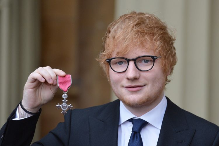 Artis musik Inggris, Ed Sheeran, berfoto dengan medali kehormatan Member of the Order of the British Empire (MBE) atas prestasinya di dunia seni dan sosial. Penghargaan itu diserahkan di Buckingham Palace oleh Prince of Wales atau Pangeran Charles, Kamis (7/12/2017).