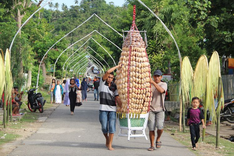 Masyarakat Desa Bongo, Batudaa Pantai, Kabupaten Gorontalo membawa tolangga yang dihias dengan kue kolombengi ke masjid At-Taqwa. 