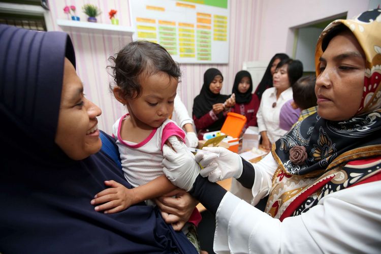 Seorang bocah mendapatkan imunisasi difteri di Puskesmas Kalimulya, Depok, Jawa Barat, Rabu (13/12/2017). Kota Depok masuk dalam kategori kejadian luar biasa (KLB) difteri setelah sejak November 2017, kasus infeksi difteri di Jawa Barat mencapai 109 kasus, 13 orang di antaranya meninggal.