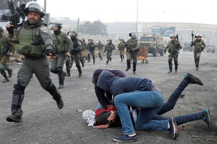 Petugas keamanan Israel yang menyamar menahan pengunjuk rasa Palestina saat memprotes keputusan Presiden Amerika Serikat Donald Trump yang mengakui Yerusalem sebagai ibu kota Israel, dekat permukiman Yahudi Beit El, Kota Ramallah, Tepi Barat, Rabu (13/12/2017).