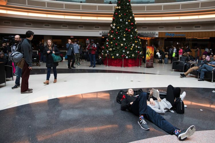 Terlihat pasangan sedang bersantai di atrium di luar jalur keamanan domestik, di Bandara Internasional Hartsfield-Jackson di Atlanta, Amerika Serikat, Minggu (17/12/2017). (The New York Times/Dustin Chambers)