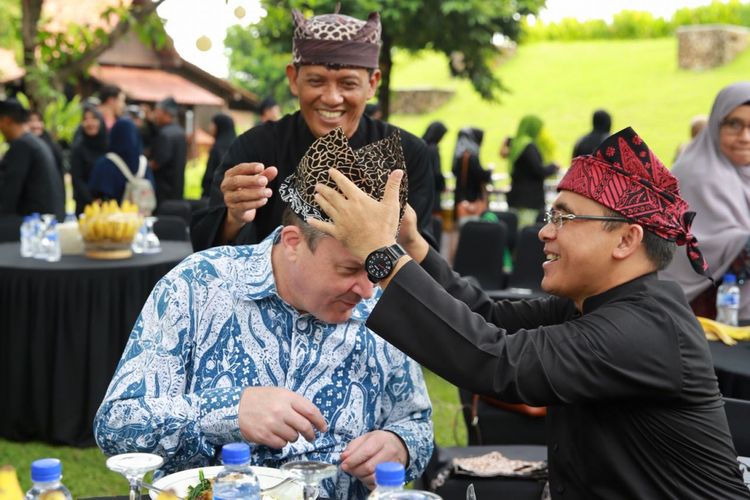 Bupati Banyuwangi Abdullah Azwar Anas membantu Konsul Jenderal Australia di Surabaya, Chris Barnes memasang udeng, ikat kepala khas Suku Osing, Senin (18/12/2017). 