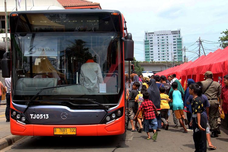 Masyarakat bersiap menaiki fasilitas bus Tanah Abang Explorer di Jalan Jatibaru, Tanah Abang, Jakarta, Jumat (22/12/2017). Sehubung keputusan Gubernur DKI Jakarta Anies Baswedan, ruas jalan di depan stasiun ditutup untuk kendaraan bermotor pada pukul 08.00-18.00 WIB.