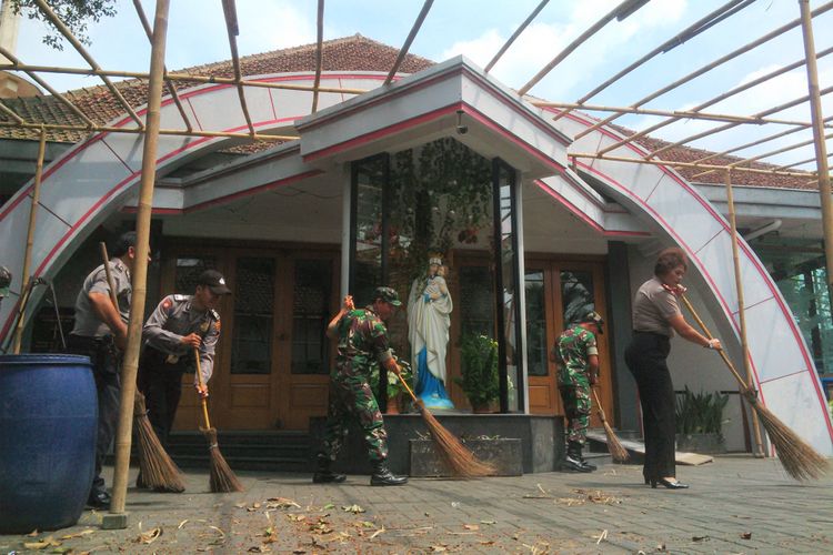 Kompol Juliana bersama anggota TNI menyapu halaman Gereja SP Maria Regina Purbowardayan di Solo, Jawa Tengah, Selasa (26/12/2017).