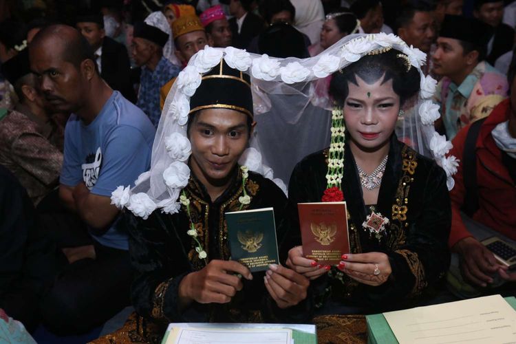 Sepasang pengantin menunjukkan buku nikahnya usai mengikuti nikah massal di jalan MH Thamrin, Jakarta Pusat, Minggu (31/12/2017). Nikah massal yang diadakan oleh pemerintah DKI Jakarta ini diikuti sebanyak 437 pasangan pengantin dari berbagai usia.