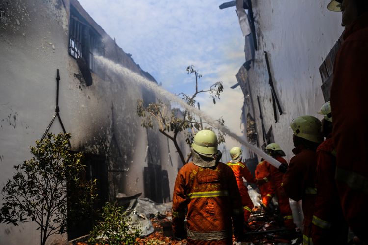 Petugas pemadam kebakaran memadamkan sisa api di Gedung Museum Bahari, Jalan Pasar Ikan, Penjaringan, Jakarta Utara, Selasa (16/1/2018). Kebakaran yang terjadi di Museum Bahari mengakibatkan koleksi miniatur model dan alat-alat navigasi bersejarah hangus terbakar dan sebanyak 16 unit mobil pemadam kebakaran yang berasal dari Damkar Jakarta Utara dan Jakarta Barat tiba untuk memadamkan api.