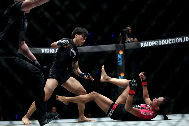 Petarung wanita China, Xiong Jing Nan (tengah) bertarung melawan petarung Singapura Tiffani Teo pada laga One Championship: Kings of Courage di Jakarta Convention Center, Sabtu (20/1/2018). Ia menjadi juara dunia kelas strawweight setelah berhasil menang lewat technical knockout pada ronde keempat.