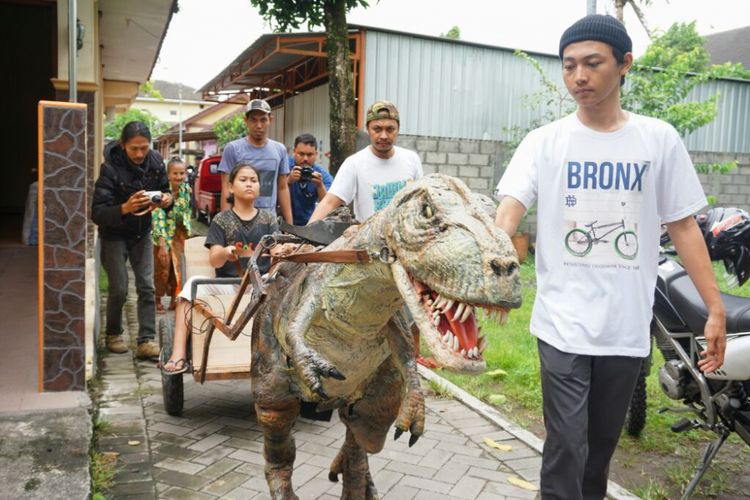   Muhammad Iqbal Firmansyah (kaos putih, memegang tali kendali di kepala T-Rex) saat mencoba animasi elektronik (animatronik) T-Rex atau Tyrannosaurus Rex. 