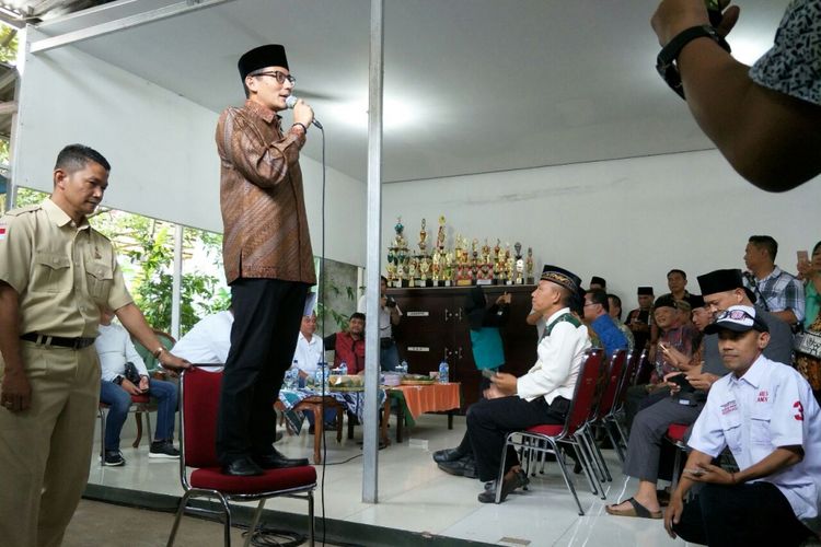 Wakil Gubernur DKI Jakarta Sandiaga Uno pidato berdiri di atas kursi di hadapan warga Kalisari, Minggu (28/1/2018). 