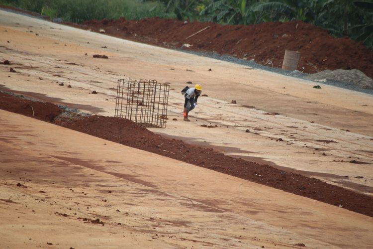 Pekerja menyelesaikan proyek pembangunan jalan tol akses Serpong - Kunciran sepanjang 11,20 km di Kawasan Jombang Ciputat, Tangerang Selatan, Banten, Jumat (02/02/2018). Jalan tol  ini merupakan bagian dari jaringan Tol JORR 2 yang nantinya akan menghubungkan Bandara Soekarno Hatta hingga Bitung Tangerang dan diharapkan mampu memecahkan penumpukan serta kemacetan yang ada di tol dalam kota maupun tol JORR.