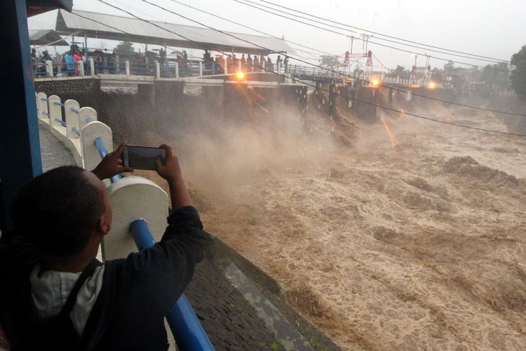 Warga berada di sekitar Bendung Katulampa di Kota Bogor, Jawa Barat, Senin (5/2/2018). Bendung Katulampa menunjukkan status siaga satu setelah ketinggian muka air mencapai 220 sentimeter, hal tersebut disebabkan tingginya intensitas yang mengguyur wilayah Bogor dan Puncak dari malam hingga pagi hari. ANTARAFOTO/Yulius Satria Wijaya/Spt/18.